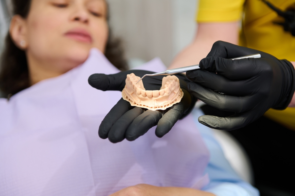 orthodontist holding dental plaster mold - dentures