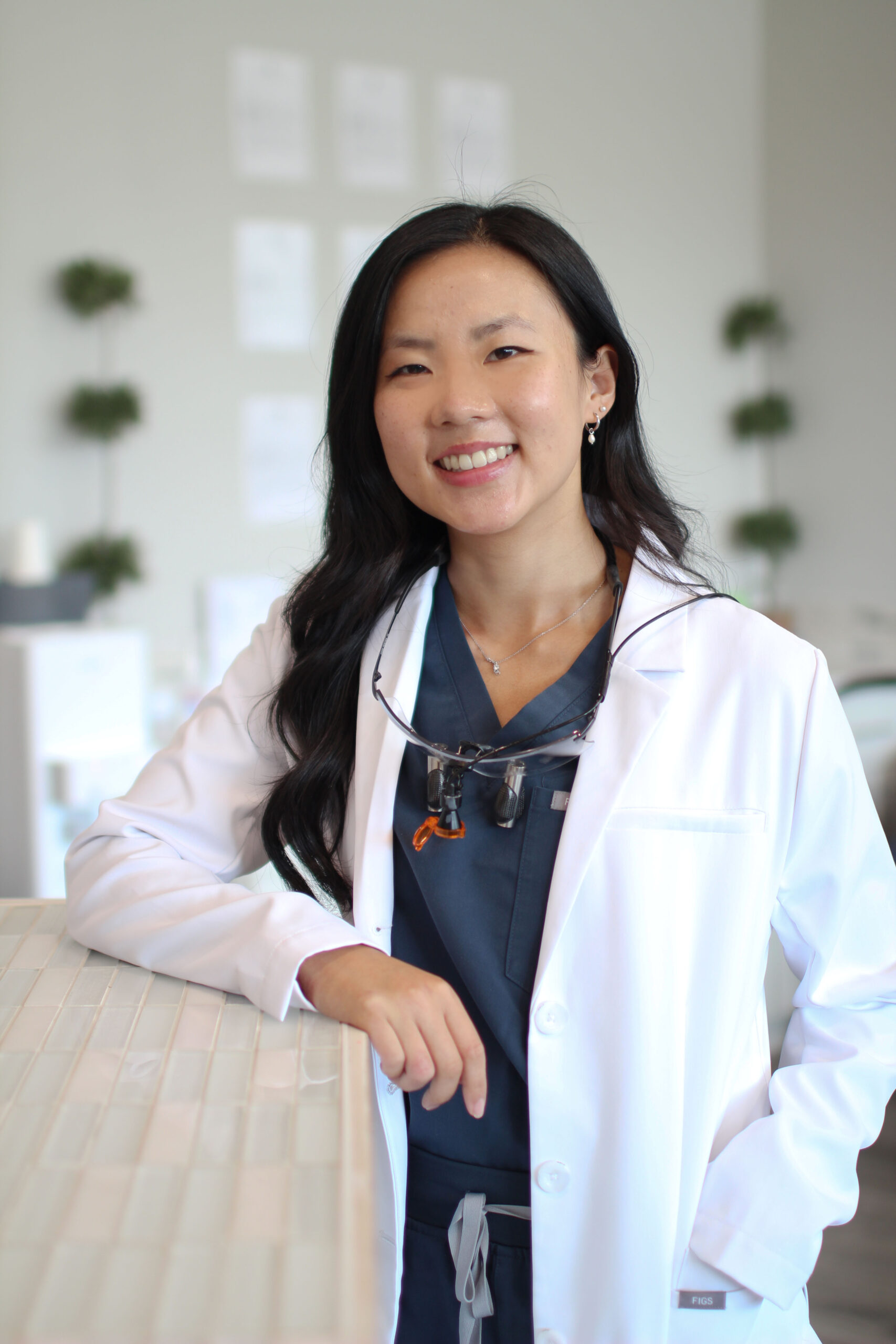 Dr. Sarah Park, DDS of WA Dental leaning on a desk - Dentist Federal Way WA