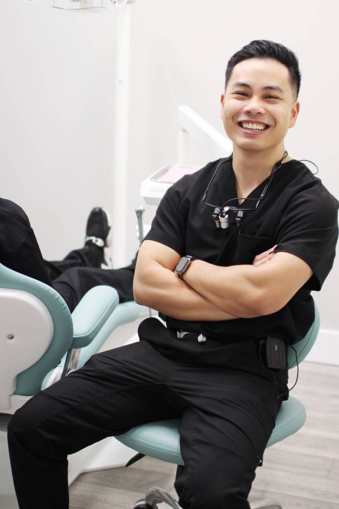 Dr. John Bui, DMD of WA Dental wearing scrub uniform sitting in the dental room - Dentist Federal Way WA Dr. John Bui, DMD of WA Dental wearing scrub uniform sitting in the dental room - Dentist Federal Way WA