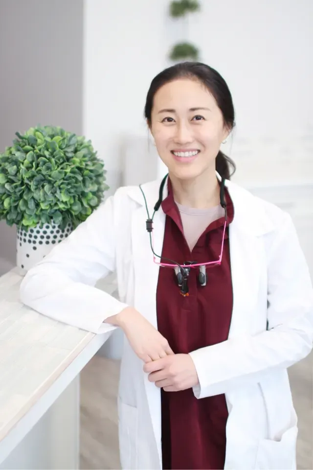 Dr. Junkyung Lee, DMD of WA Dental leaning on the reception area desk - Dentist Federal Way WA Dr. Junkyung Lee, DMD of WA Dental leaning on the reception area desk - Dentist Federal Way WA