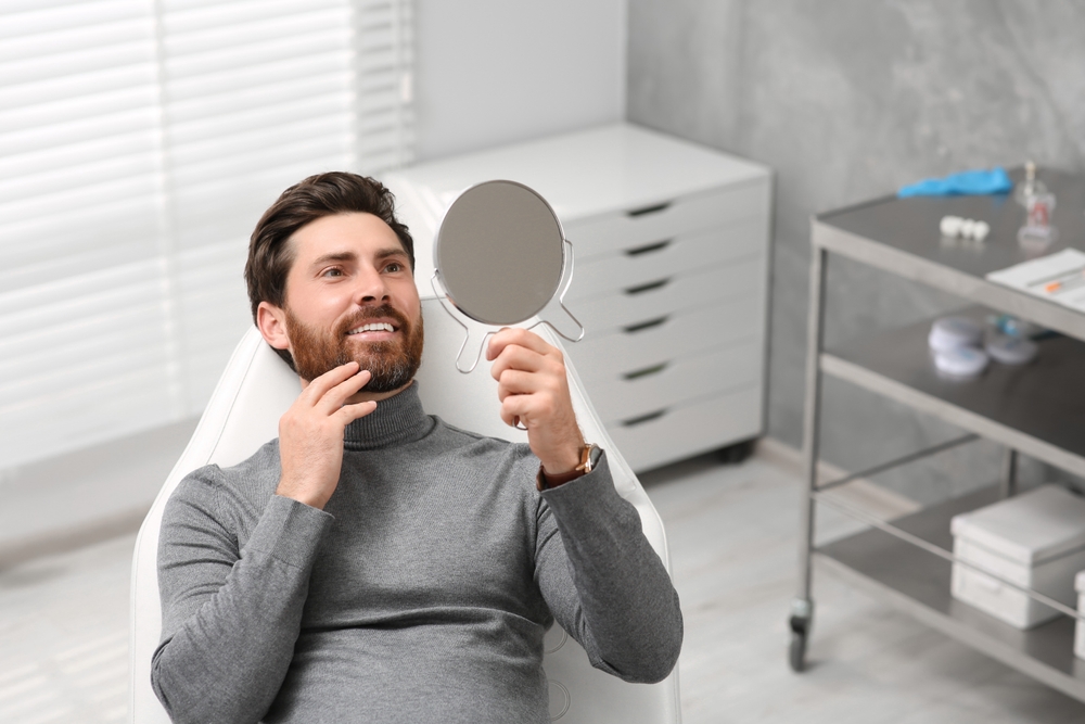 Man checking teeth at the mirror - Restorative Dentistry Man checking teeth at the mirror - Restorative Dentistry