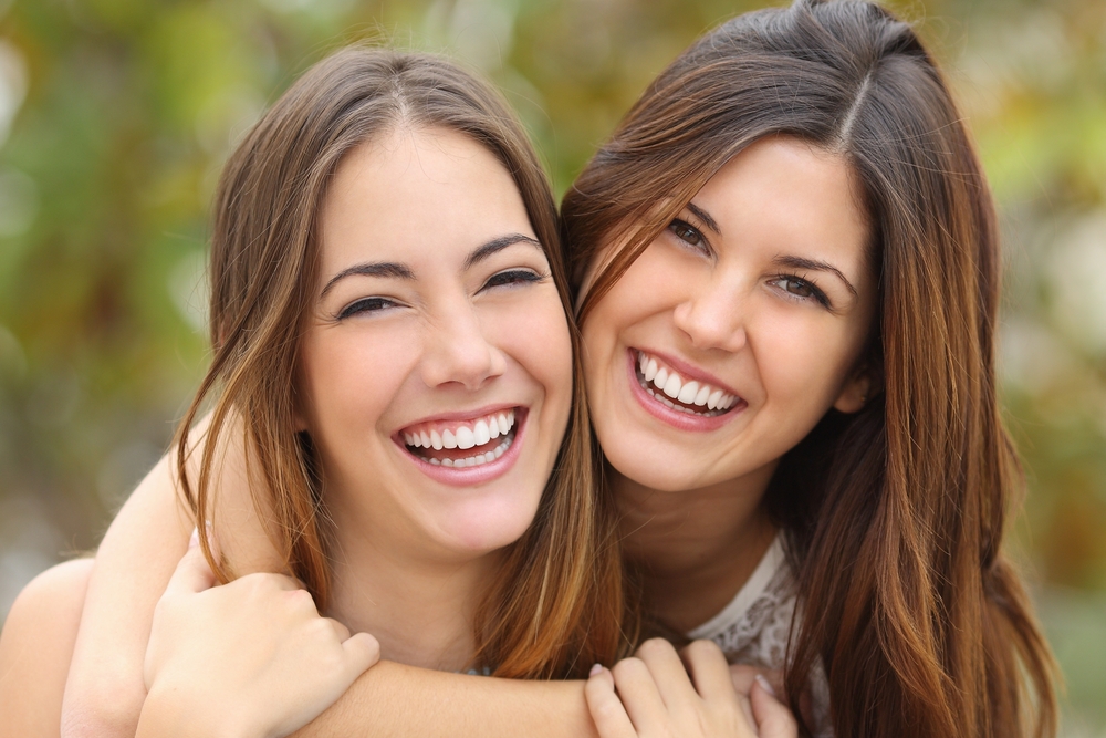 Two women friends laughing - teeth whitening Two women friends laughing - teeth whitening