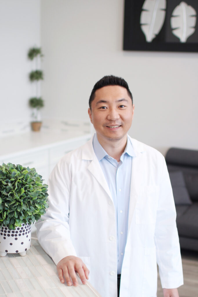 Dr. Alex Shin, DMD of WA Dental posing and arms on the white desk - Dentist Federal Way WA Dr. Alex Shin, DMD of WA Dental posing and arms on the white desk - Dentist Federal Way WA